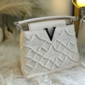 White handbag with intricate design on a fur surface