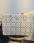 Beige handbag with a pattern on a gold stand against a light background