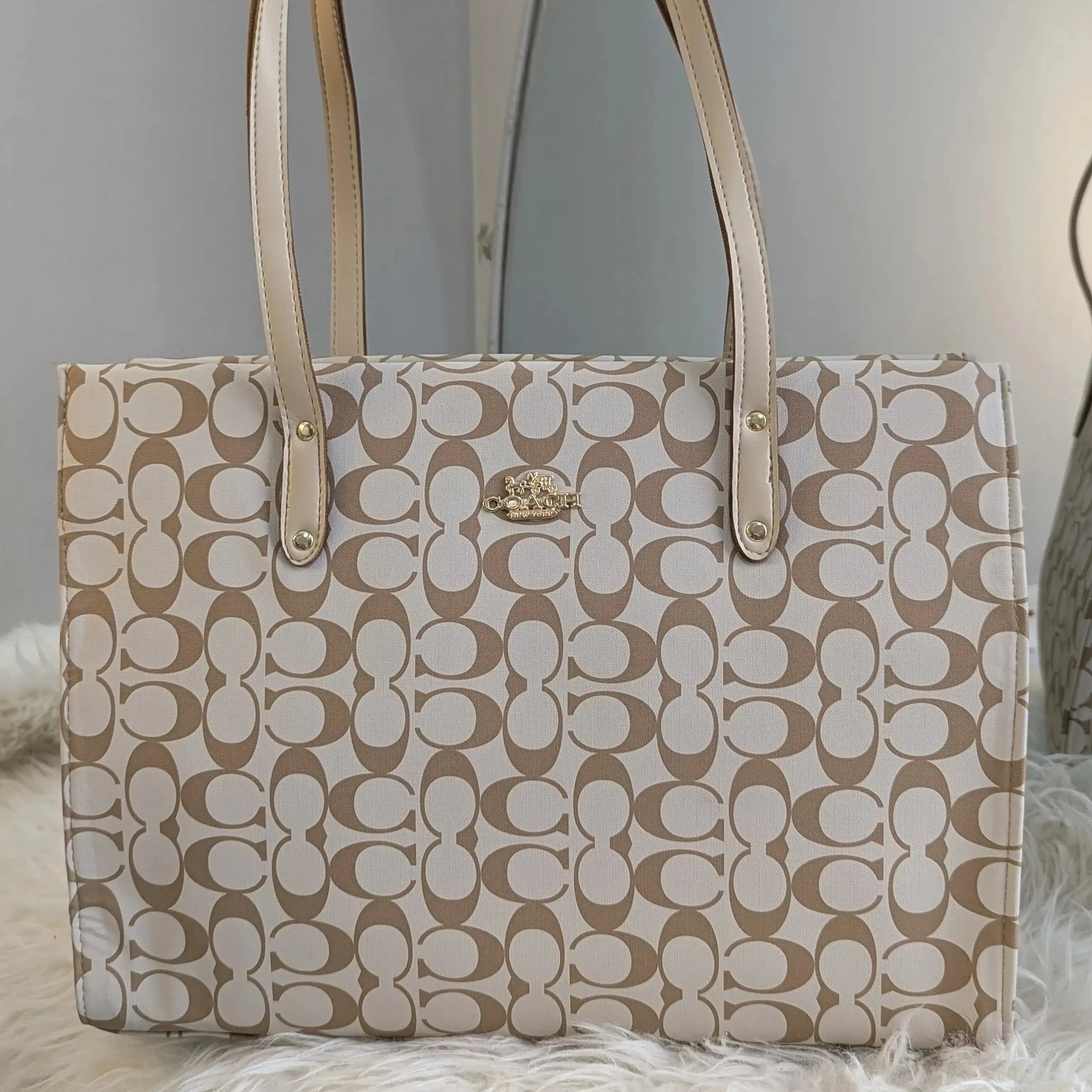 Beige handbag with a pattern on a light gray background