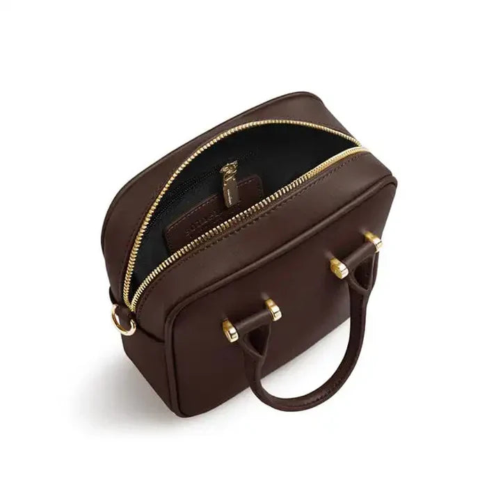 Brown handbag with gold zippers on a white background