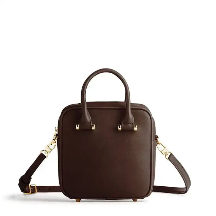 Brown leather handbag with gold accents on a white background