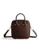 Brown leather handbag with gold accents on a white background