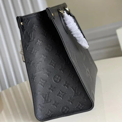 Black embossed handbag on a white surface with a neutral background