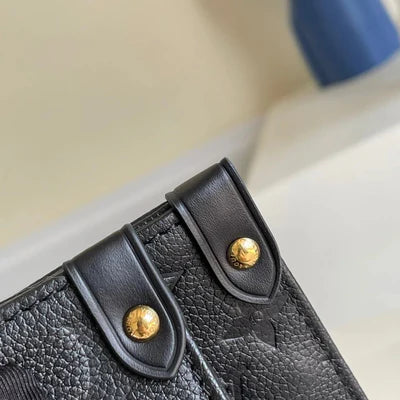 Close-up of a black leather bag with gold studs on a blurred background