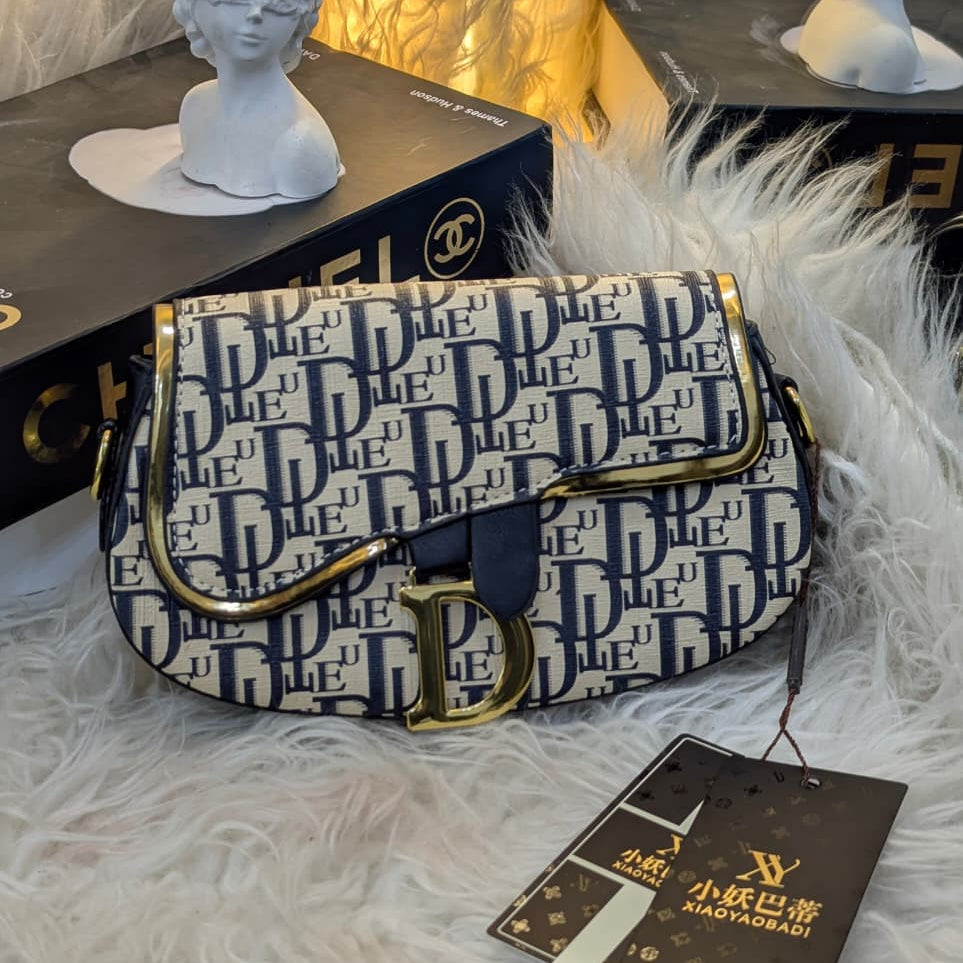 Designer handbag with visible brand logo on a textured surface