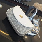 Patterned pouch with gold emblem on a reflective surface