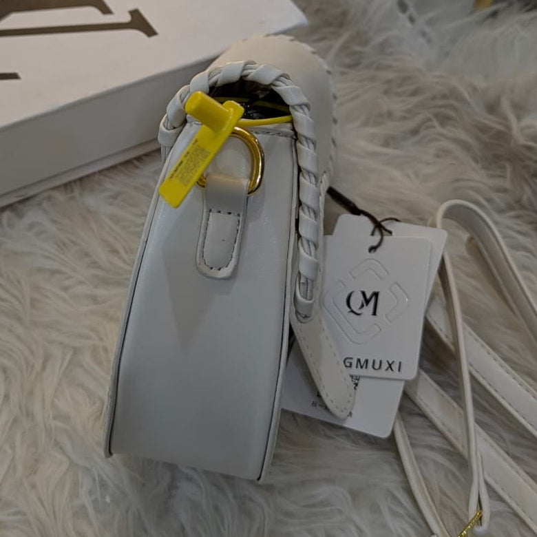 White handbag with a yellow tag on a textured surface, with a Louis Vuitton box in the background.