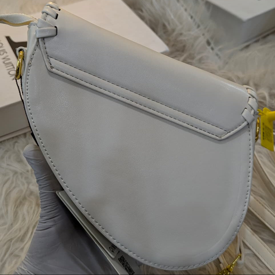White handbag on a fluffy white surface with a blurred background